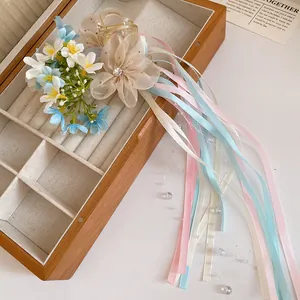 Macro detail view showing textures of the ballet-style ribbon and floral hair claw clip