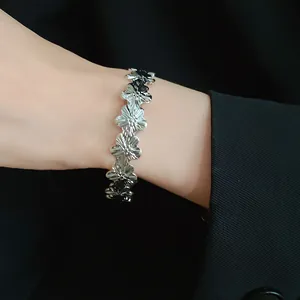 Close-up detailed view of vintage silver metal flower cuff bracelet worn on the wrist