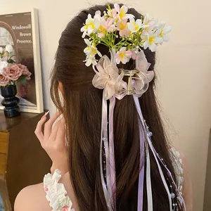 Back view of an elegant floral hair claw clip with long pastel ribbons and beads.