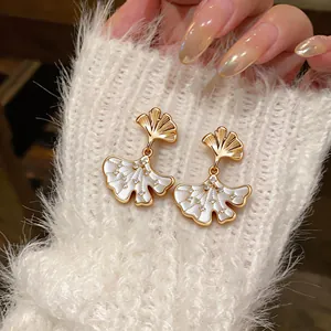 Detailed close-up showing elegant ginkgo leaf earrings with white shell inlay and zircons