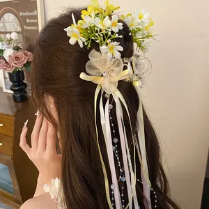 Close-up detail of a ballet style ribbon flower hair clip with streamers on model's hair