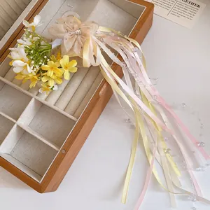 Detailed close-up of a ballet style hair clip with mesh flower and long pastel ribbons