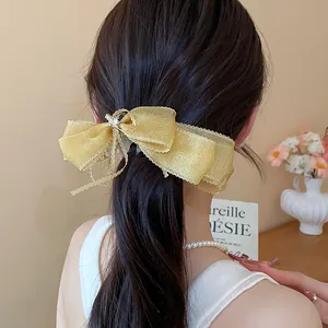 Detalle de un elegante pasador de lazo de encaje dorado con estrella en una coleta.