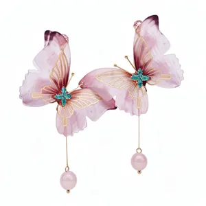 Pendientes mariposa violeta elegantes con filigrana dorada y cristales verde azulado.