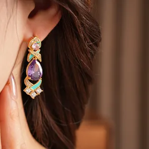 Primer plano de pendiente con circón púrpura y detalles de esmalte turquesa elegante