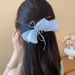 Elegante pinza para el cabello con lazo de encaje azul en pelo largo y oscuro