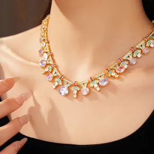 Detalle de un collar dorado de estilo palaciego con circonitas de colores y detalles de esmalte.