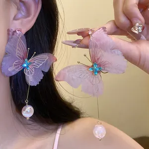 Primer plano detallato de grandes pendientes de mariposa morada con cristales azules