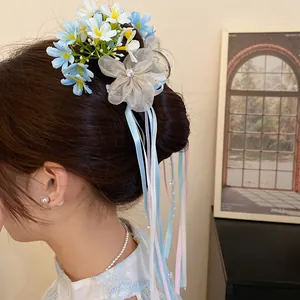 Close-up of ballet style floral hair clip with pastel ribbons worn on a side bun hairstyle