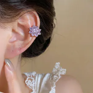 Gedetailleerd zicht op een elegante paarse zirkoon bloem oorklem aan het oor van een model