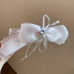 Detalle de pinza para el pelo con lazo de encaje rosa y corazón de cristal