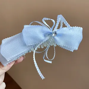 Detalle de un pasador de pelo con lazo de encaje azul claro y una estrella brillante