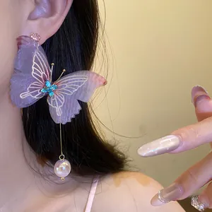 Vista detallada de pendientes de mariposa de organza púrpura con cristal azul