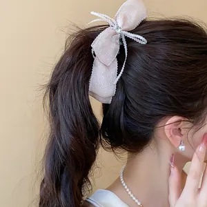 Vista detallada de un elegante pasador de encaje rosa con lazo en una coleta de modelo