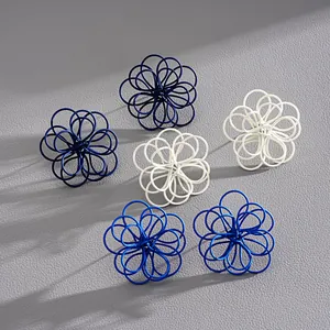 Vista detallada de pendientes de botón con forma de flor de alambre pintado en azul y blanco