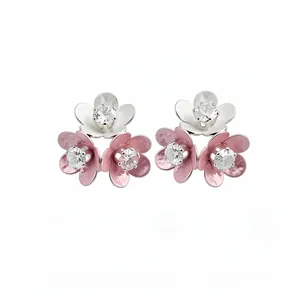 Elegant flower stud earrings with sparkling zircons and pink enamel petals on white background