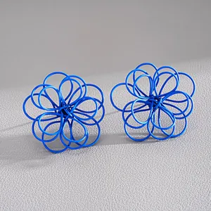 Vista detallada de primer plano de pendientes de botón con forma de flor hueca azul
