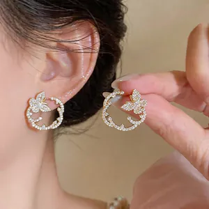 Macro view of elegant gold-toned zircon butterfly circle stud earrings for women