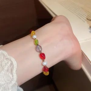 Close-up of colorful stone beaded bracelet with white pearls on a woman's wrist.