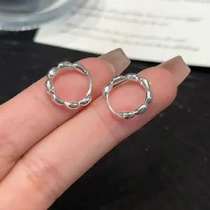 Detailed close-up showing the intricate wavy design of these silver scalloped hoop earrings
