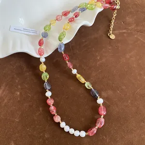 Close-up of colorful beaded necklace with pearls and gold extension chain detail