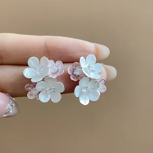 Detailed close-up view of sweet flower stud earrings featuring zircons and pink enamel accents