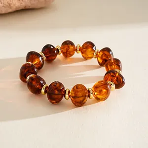Vintage amber-colored oval acrylic beaded bracelet with gold-tone spacers detail view