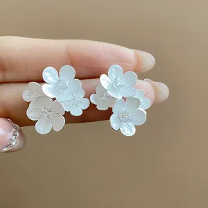 Detail of elegant white flower stud earrings with shimmering zircon center stone.