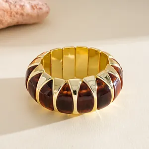 Detailed macro view of vintage amber acrylic and gold segments on a chunky elastic bracelet