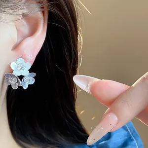 Macro detail of elegant silver needle zircon flower stud earrings with drip oil enamel finish