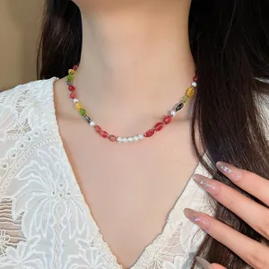 Close-up detail of a colorful natural stone and pearl beaded necklace on a model