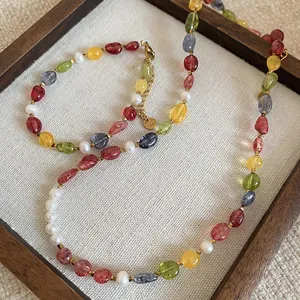 Detailed view of a colorful stone beaded necklace with pearls on a textured background