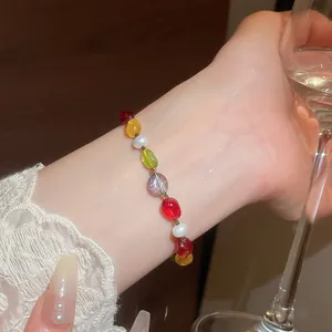 Close-up detail of a vibrant colorful stone and pearl beaded bracelet worn on a wrist
