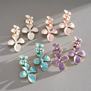 Vue détaillée de boucles d'oreilles fleurs en émail coloré avec strass en quatre couleurs.