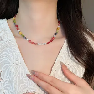 Detail view of colorful dopamine beaded necklace with pearls on a model wearing lace.