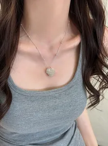 Detailed close-up view of a silver beaded heart necklace worn by a female Asian model