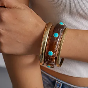 Detailed view of retro resin and gold-tone bracelets featuring turquoise accents