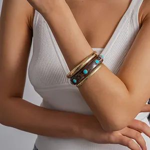 Close-up of 3-piece vintage resin and gold geometric bangles worn on a model's wrist