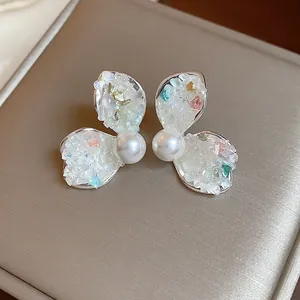 Detailed close-up view of elegant crushed stone petal earrings with pearl center
