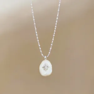 Elegant necklace featuring a cotton pearl pendant with a sparkling star accent chain.