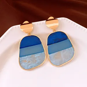 Dettaglio di orecchini vintage con pendente in acrilico blu a tre tonalità