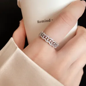Close-up macro view of a silver scalloped lace ring with pavé zircons on a finger