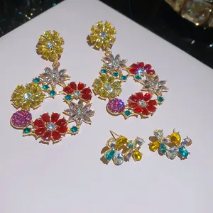 Primo piano di orecchini a cerchio con strass floreali colorati e borchie abbinate
