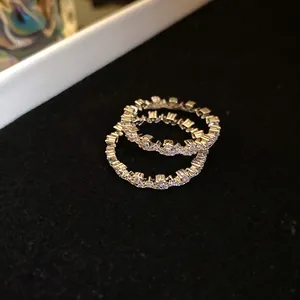 Macro view of silver-toned lace-edged rings with sparkling cubic zirconia settings