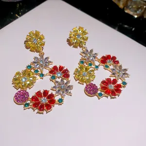 Dettaglio dei vivaci cristalli multicolori e del design floreale di questi orecchini.