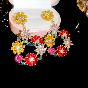 Primo piano di orecchini a cerchio con fiori di strass e gemme multicolori brillanti