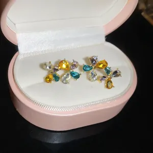 Vista dettagliata di eleganti orecchini a lobo a fiore con gemme multicolori vivaci