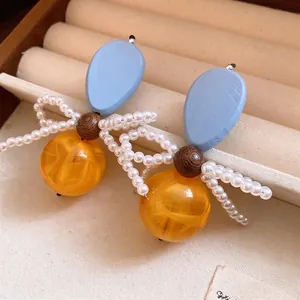 Elegant vintage style blue wood and amber resin drop earrings with white pearl bow