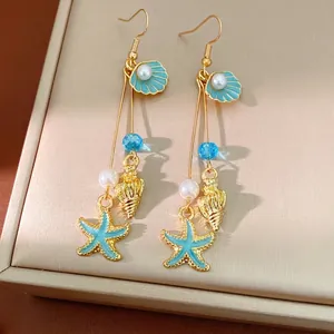 Gold-toned ocean-themed dangle earrings with shell, starfish and pearl charms for women