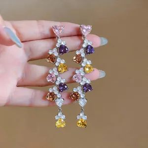 Detailed view of dangling earrings featuring vibrant multicolored heart-shaped zircon stones.